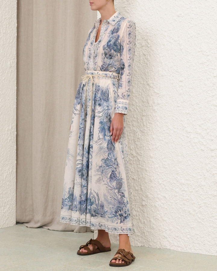 Woman wearing a long floral dress with a neutral background